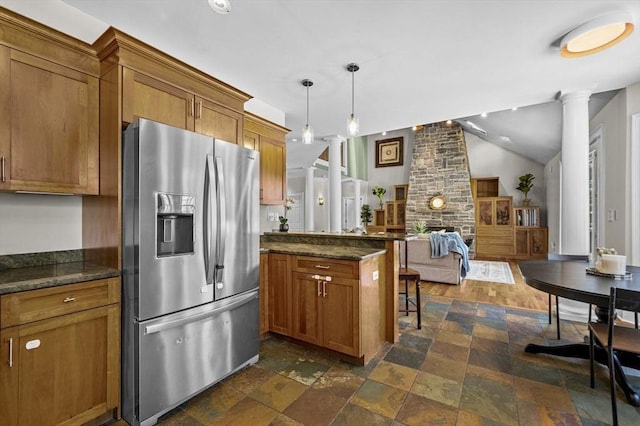 kitchen with ornate columns, vaulted ceiling, pendant lighting, a kitchen breakfast bar, and stainless steel fridge with ice dispenser