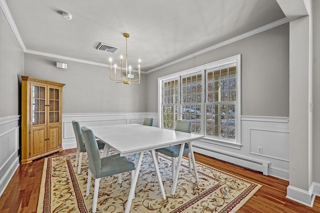 dining area featuring baseboard heating, wood-type flooring, a chandelier, and a wealth of natural light