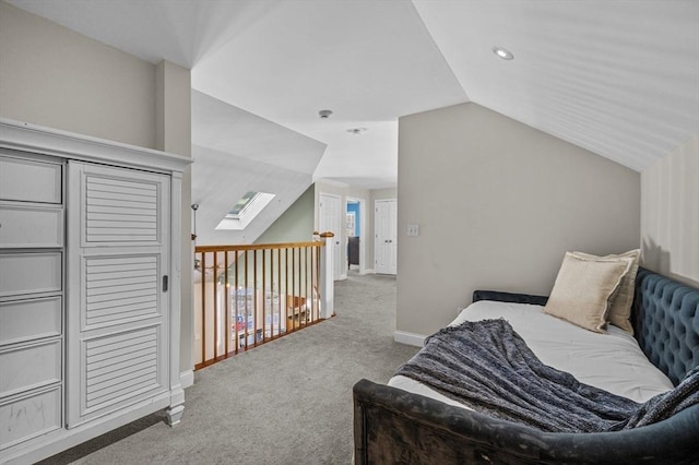 carpeted bedroom featuring lofted ceiling with skylight