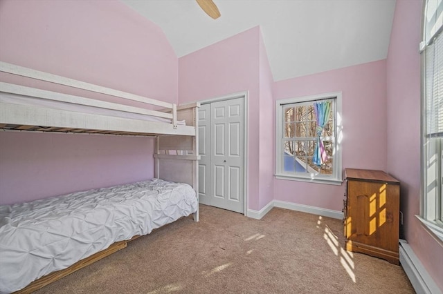 carpeted bedroom with vaulted ceiling, a baseboard radiator, ceiling fan, and a closet