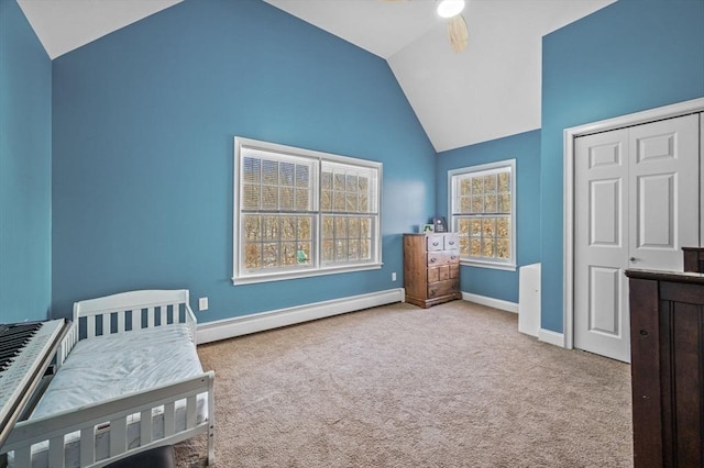 carpeted bedroom with lofted ceiling, a baseboard heating unit, ceiling fan, and a closet