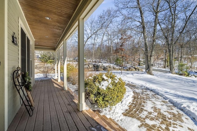 snow covered deck featuring a porch