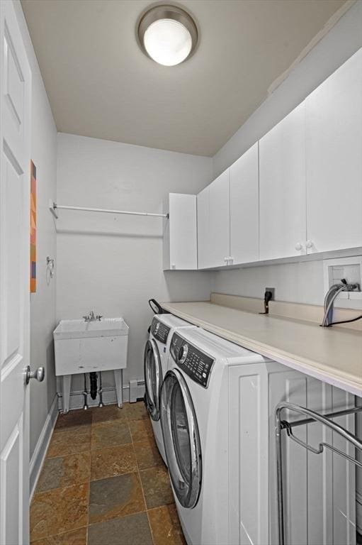 washroom with cabinets, a baseboard heating unit, and washer and clothes dryer