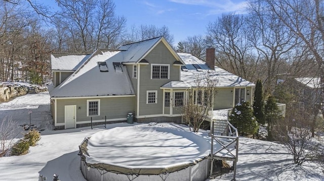 view of snow covered rear of property