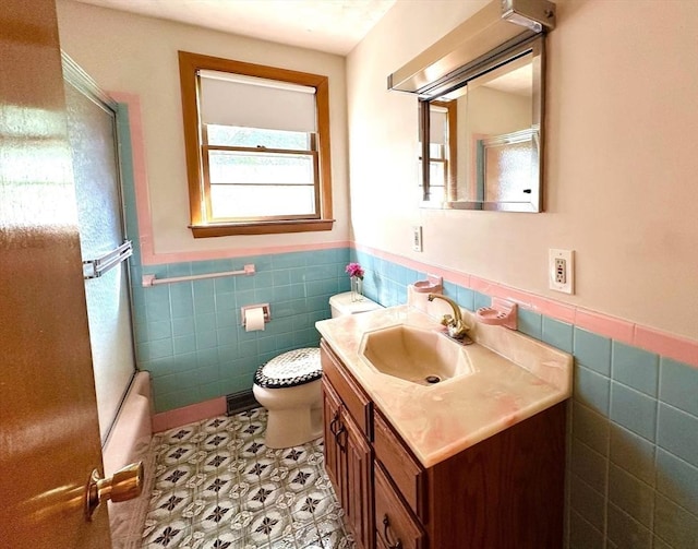 333 Clark Rd, Lowell, MA 01852 - full bathroom featuring tile walls, vanity, wainscoting, toilet, and enclosed tub / shower combo