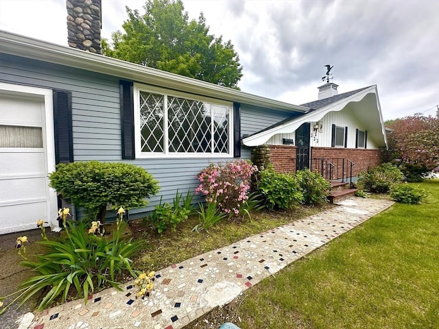 333 Clark Rd, Lowell, MA 01852 - view of front of home with a chimney, brick siding, and a garage