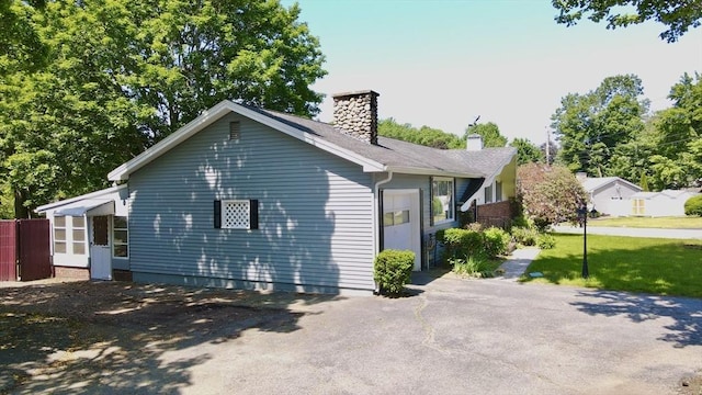333 Clark Rd, Lowell, MA 01852 - view of side of property with a chimney, driveway, and a garage