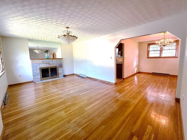 333 Clark Rd, Lowell, MA 01852 - unfurnished living room with a chandelier, wood finished floors, baseboards, and arched walkways