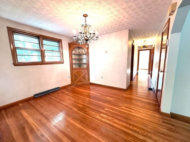 333 Clark Rd, Lowell, MA 01852 - unfurnished dining area featuring wood finished floors, a chandelier, baseboards, and a textured ceiling