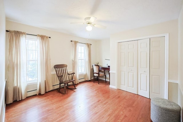 living area featuring a wealth of natural light, ceiling fan, and hardwood / wood-style flooring