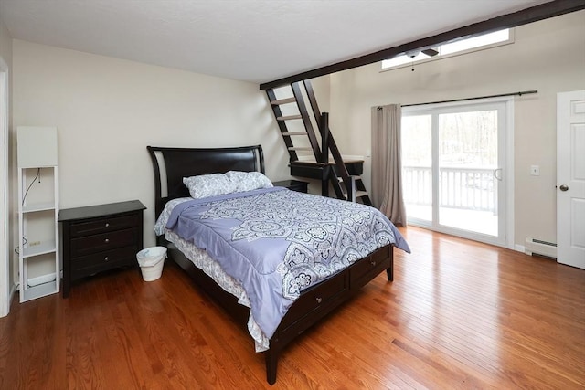 bedroom featuring access to exterior, wood-type flooring, and baseboard heating