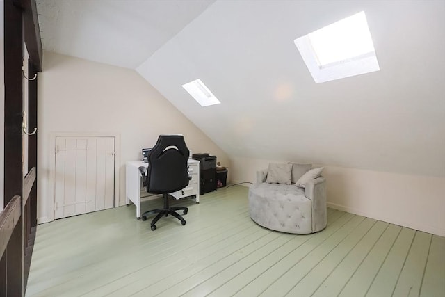 home office featuring hardwood / wood-style floors and vaulted ceiling with skylight