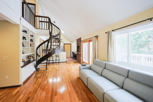 living room with light hardwood / wood-style floors and high vaulted ceiling