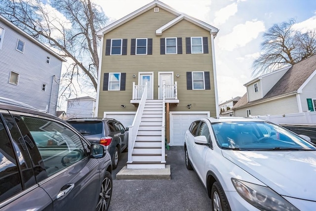 view of front of house featuring a garage, stairs, and aphalt driveway