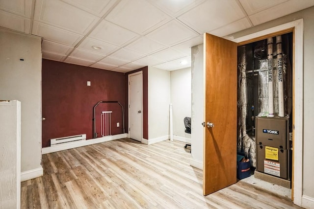 finished basement featuring wood finished floors, baseboards, and a baseboard radiator