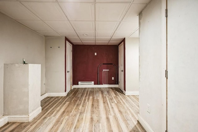 unfurnished room with baseboards, baseboard heating, and light wood finished floors