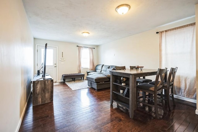 dining space with dark wood-style floors, baseboards, and a textured ceiling