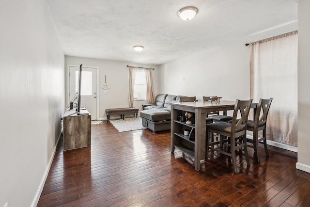 dining area featuring baseboards and dark wood-style flooring