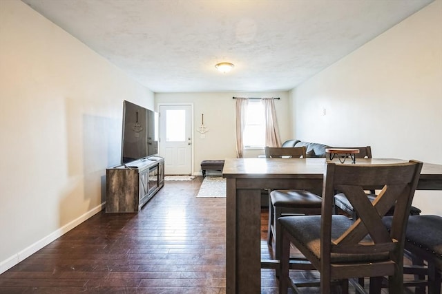 dining area featuring dark wood-style floors, a textured ceiling, and baseboards
