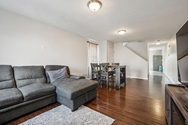 living area featuring stairs, baseboards, and hardwood / wood-style flooring