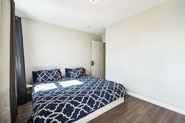 bedroom with baseboards and wood finished floors