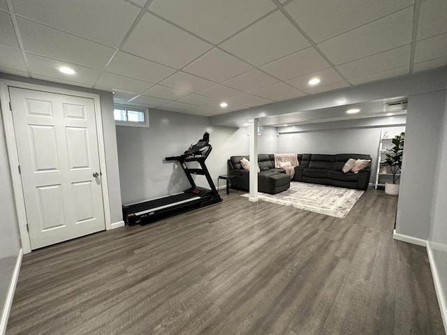 exercise room with a paneled ceiling and dark hardwood / wood-style flooring