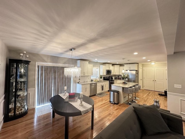 living room with sink, wine cooler, and light hardwood / wood-style flooring