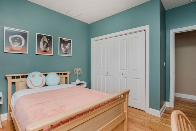 bedroom with light hardwood / wood-style floors and a closet