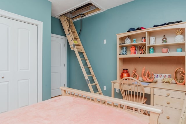 bedroom featuring a closet, built in desk, and a crib