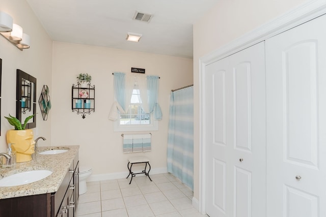 bathroom featuring walk in shower, vanity, tile patterned floors, and toilet