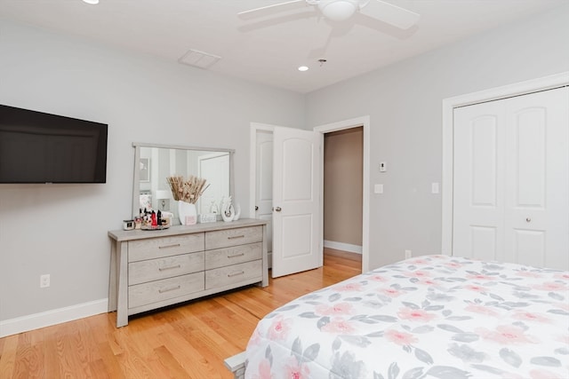 bedroom with light hardwood / wood-style floors, ceiling fan, and a closet