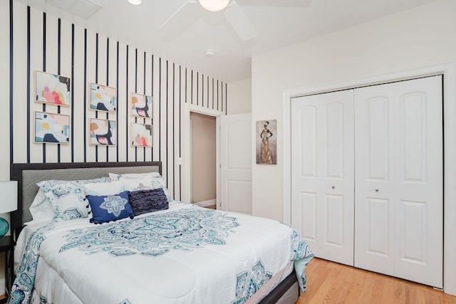 bedroom with hardwood / wood-style flooring, ceiling fan, and a closet