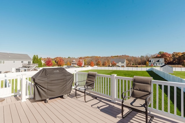 wooden deck with a lawn and a grill