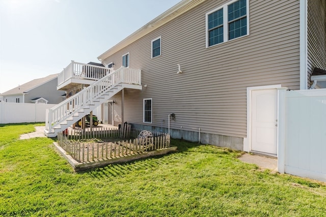 rear view of property featuring a lawn and a deck