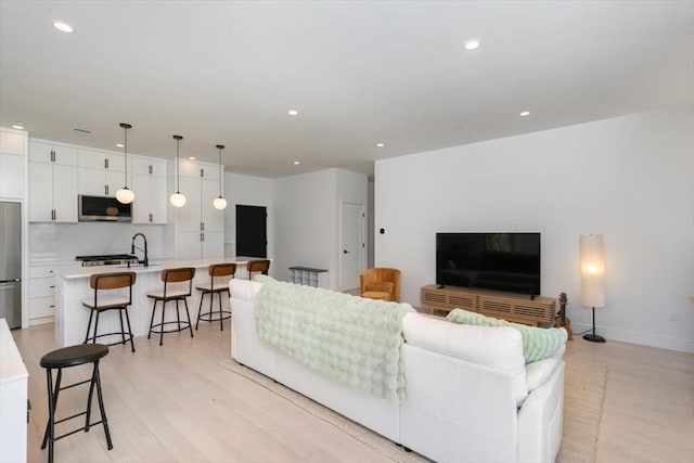 living room with sink and light wood-type flooring