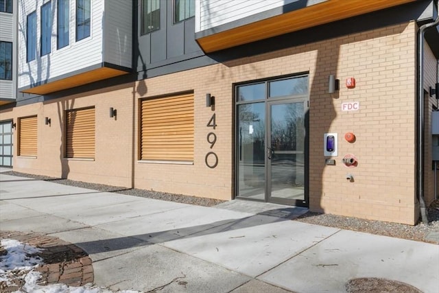 property entrance with a garage and brick siding