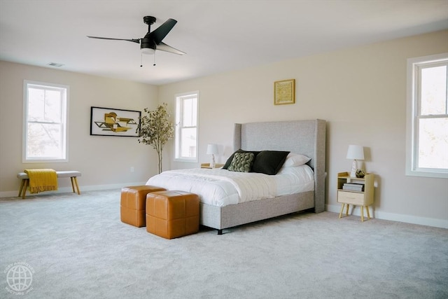 carpeted bedroom featuring multiple windows, ceiling fan, and baseboards