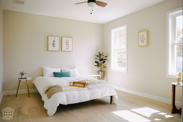 bedroom with light wood-style floors, baseboards, and a ceiling fan
