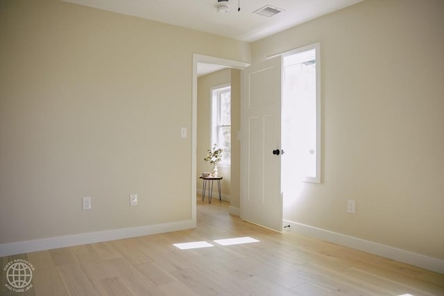 unfurnished room with light wood-type flooring, baseboards, and a smoke detector