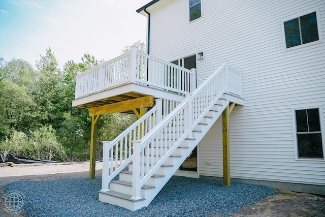 view of side of home featuring stairway and a deck