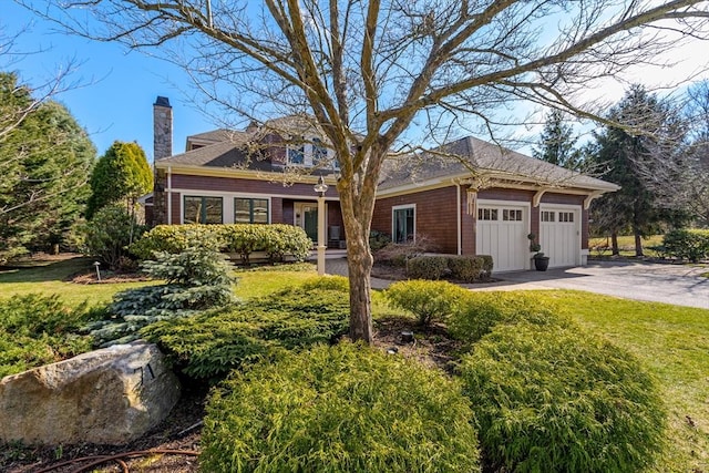 view of front of house featuring a chimney, driveway, board and batten siding, an attached garage, and a front lawn