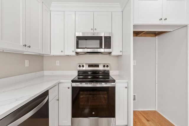 77 Minot Ave, Wareham, MA 02571 - kitchen featuring appliances with stainless steel finishes, white cabinetry, light stone countertops, and light wood-style floors