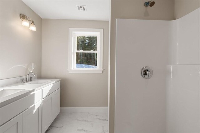 77 Minot Ave, Wareham, MA 02571 - bathroom with marble look tile flooring, a shower, double vanity, and baseboards