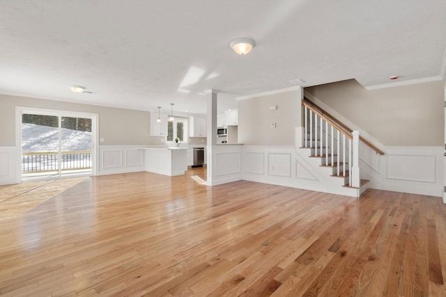 77 Minot Ave, Wareham, MA 02571 - unfurnished living room featuring a decorative wall, ornamental molding, light wood-style flooring, a wainscoted wall, and stairway
