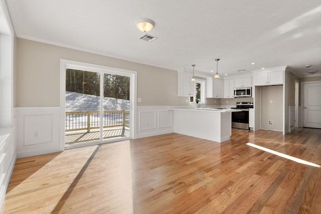 77 Minot Ave, Wareham, MA 02571 - unfurnished living room featuring ornamental molding, plenty of natural light, a decorative wall, light wood finished floors, and wainscoting