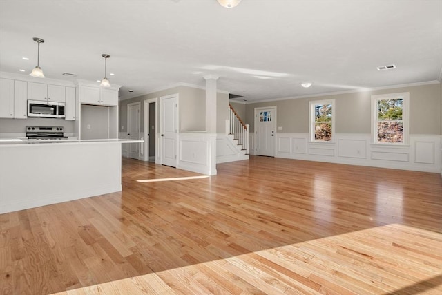 77 Minot Ave, Wareham, MA 02571 - unfurnished living room featuring ornamental molding, a decorative wall, light wood-type flooring, stairs, and wainscoting