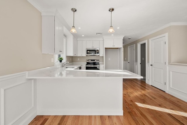 77 Minot Ave, Wareham, MA 02571 - kitchen with appliances with stainless steel finishes, a peninsula, light countertops, crown molding, and white cabinets