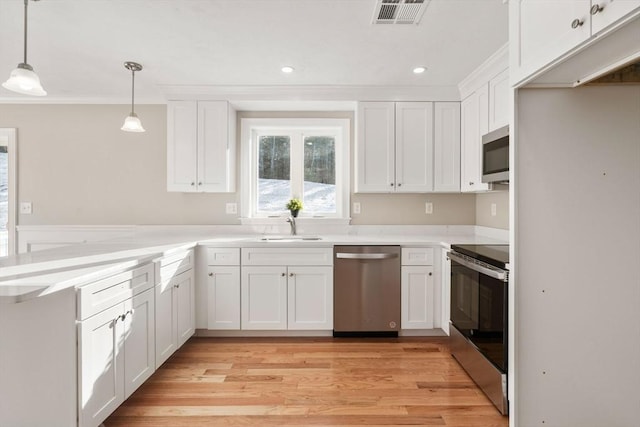 77 Minot Ave, Wareham, MA 02571 - kitchen with appliances with stainless steel finishes, a sink, a peninsula, white cabinetry, and light wood finished floors
