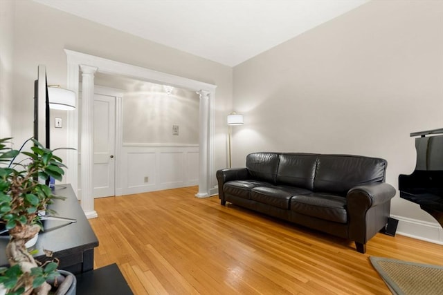 149 Winthrop Rd Unit 5, Brookline, MA 02445 - living room featuring ornate columns, light wood finished floors, a wainscoted wall, and a decorative wall