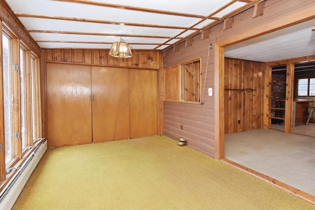 carpeted spare room with a wealth of natural light and baseboard heating